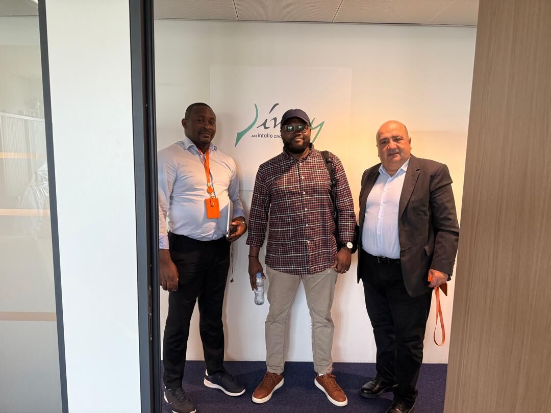 Eklin standing between two men in front of the Jiway, an Intalio Group company, logo